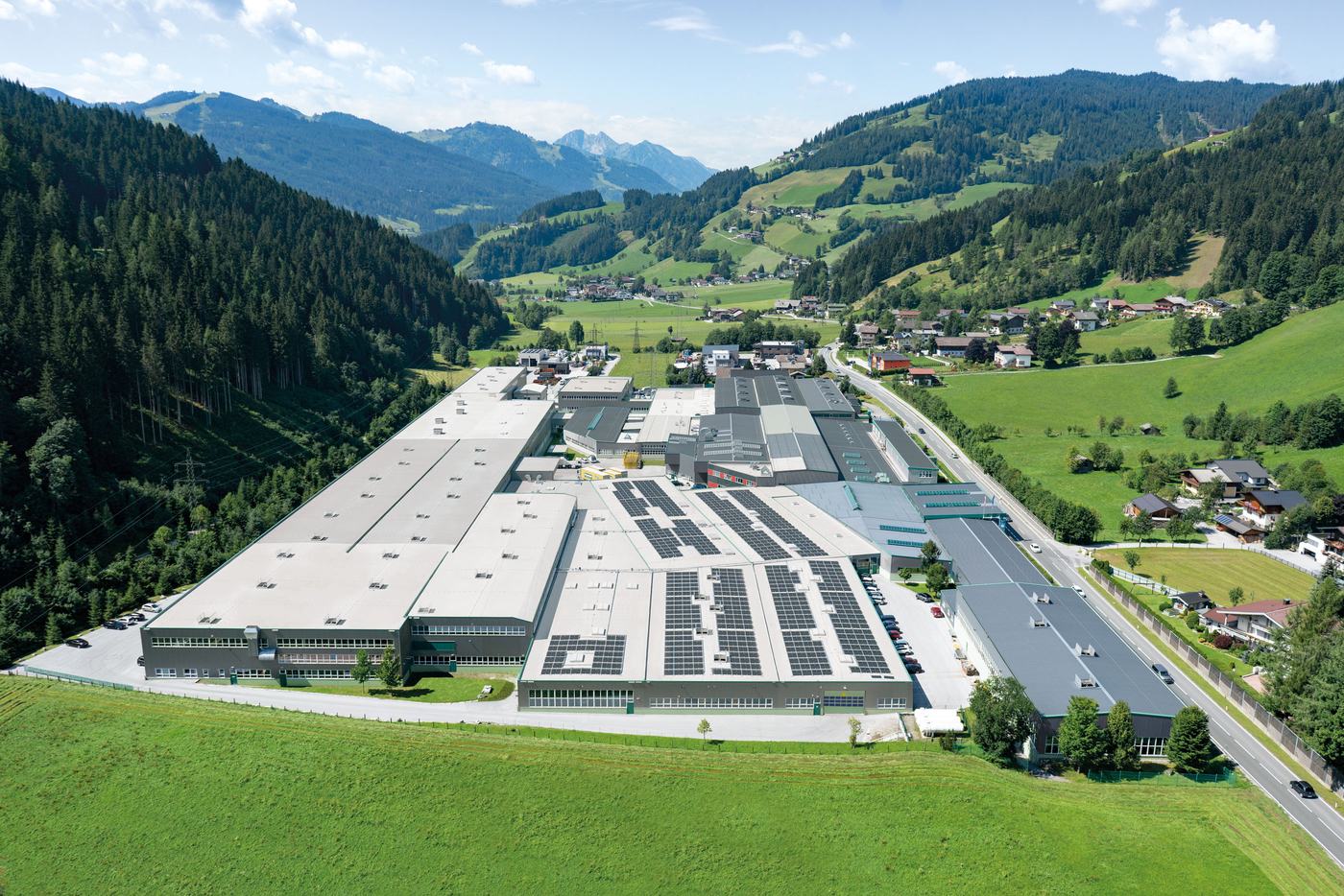 Luftaufnahme des Firmengeländes von Glas Gasperlmair in Wagrain, umgeben von Wiesen und Bergen