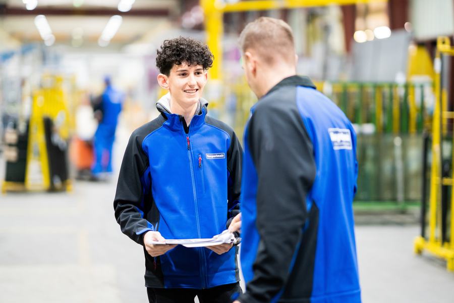 Lehrling bespricht mit seinem Ausbilder einen Arbeitsauftrag in der Produktion